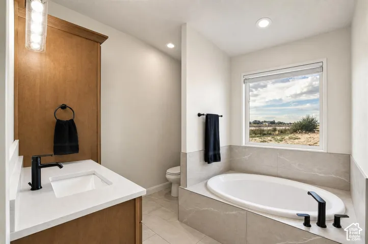 Built-in soaking tub with matte black fixtures, set within a tiled surround