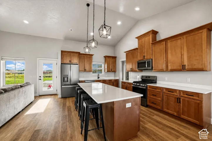 Vaulted ceilings with recessed lighting, wood-finish flooring, and white countertops