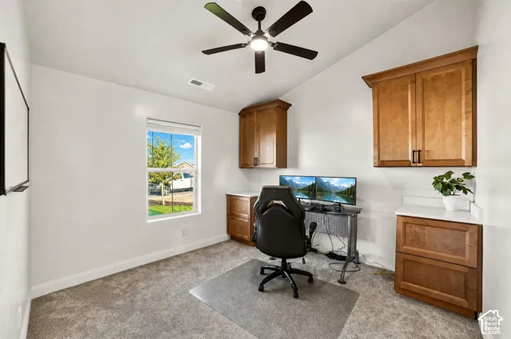Built-in wood cabinetry with stone-finish countertops, ceiling fan, and carpeted flooring