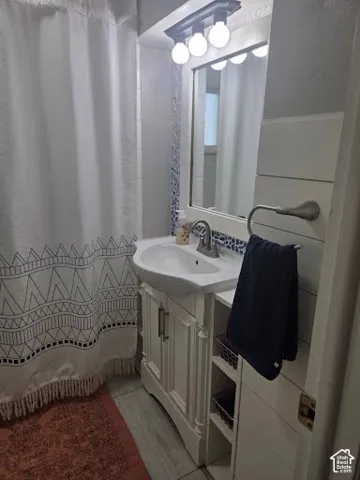 White vanity with integrated sink, brushed nickel faucet, and built-in shelving