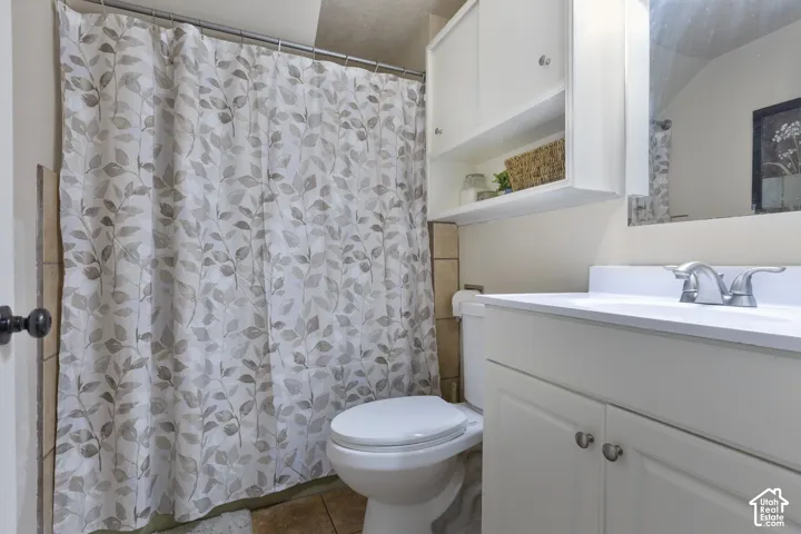 White vanity with a single basin sink and dual-handle faucet