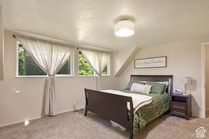 Wall-to-wall carpeting, recessed windows, and a built-in sloped ceiling detail