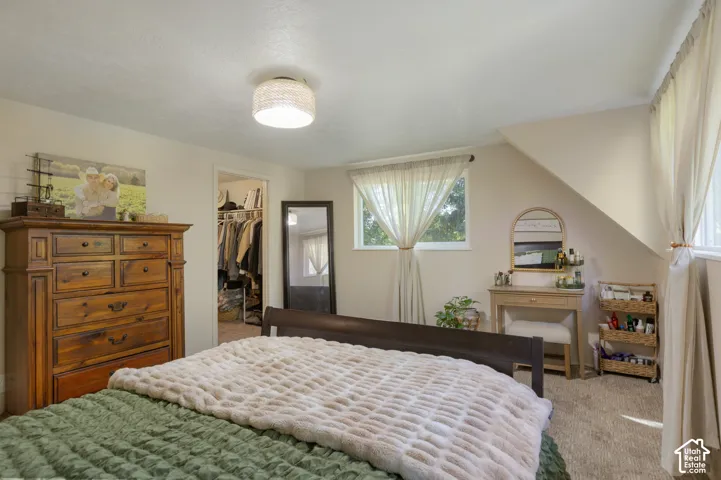 Carpeted flooring, recessed window, and sloped ceiling
