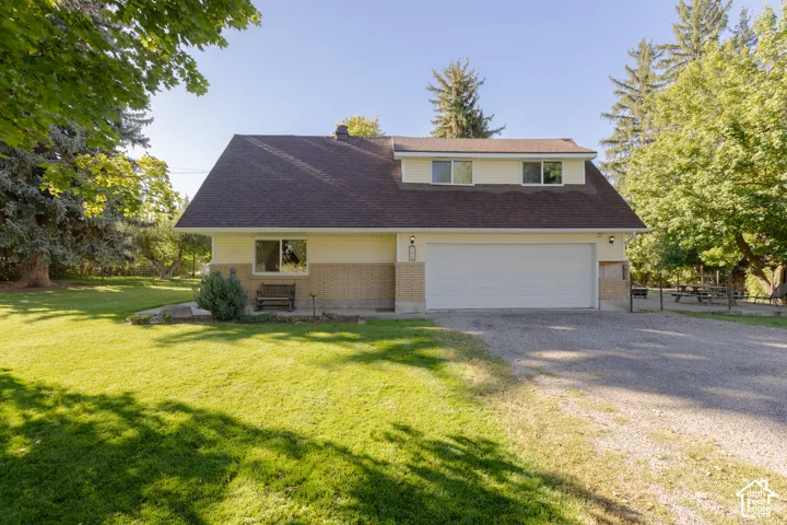 Front Exterior of property featuring two car garage, covered porch and spacious yard.