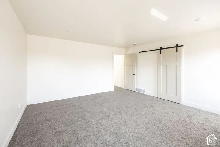 Grey carpeting, white walls, and recessed lighting
