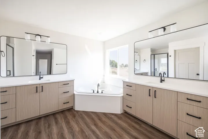 Primary Bathroom Suite featuring dual vanities with wood-finish cabinetry, white quartz countertops, and matte black hardware