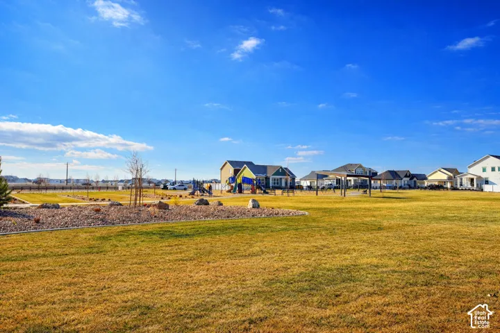 Expansive grassy area with landscaping and a playground structure