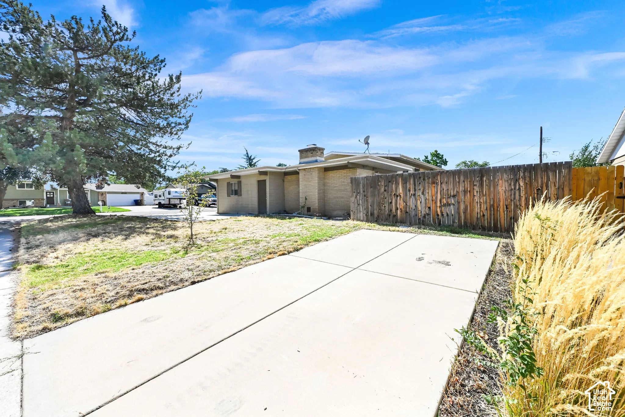 Concrete driveway with an adjacent wooden privacy fence