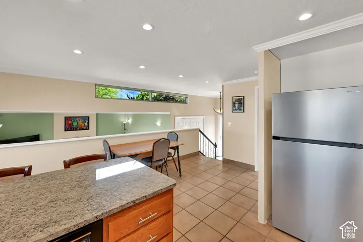 Kitchen featuring a built-in microwave, wood cabinetry, and a stainless steel refrigerator