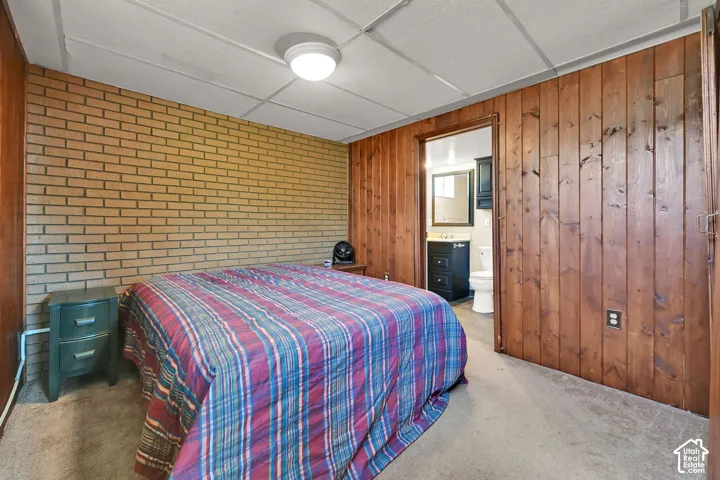Brick accent wall with wood-paneled walls