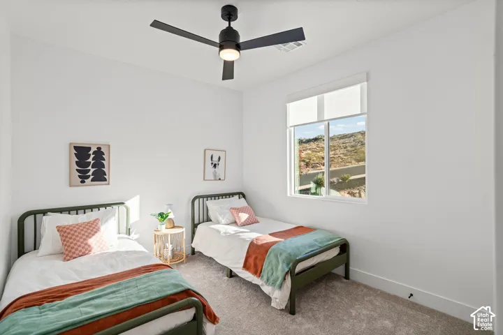 White walls with a ceiling fan, carpet flooring, and a single window