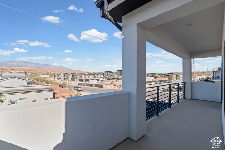 Covered outdoor balcony with a black metal railing and concrete flooring