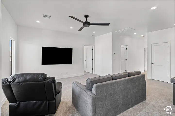 Spacious room featuring a vaulted ceiling with a ceiling fan, recessed lighting, and light-toned carpet flooring