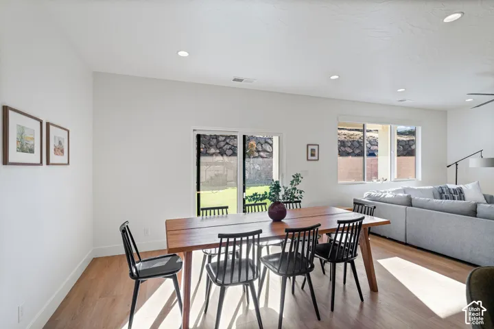 Open-concept living space with recessed lighting, wood-finish flooring, and white walls