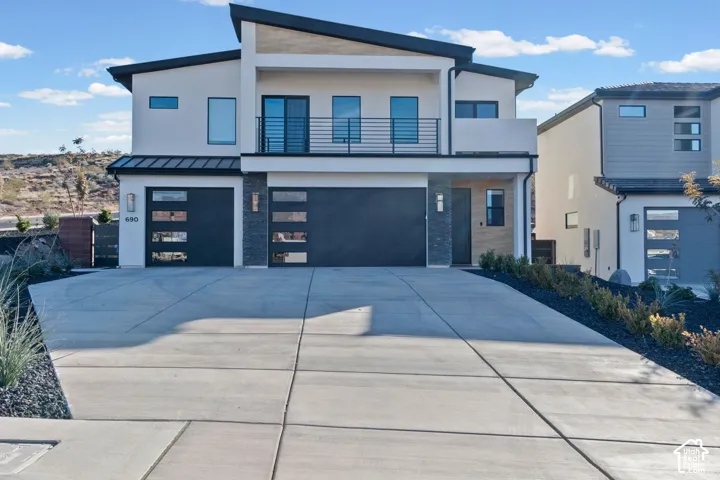 Modern stucco exterior with a distinctive angled roofline and wood-finish accents