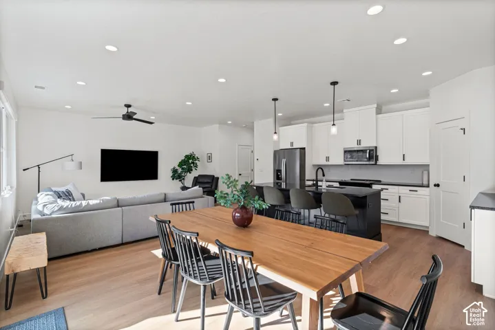 Open-concept living area featuring wood-finish flooring, recessed lighting, and a ceiling fan