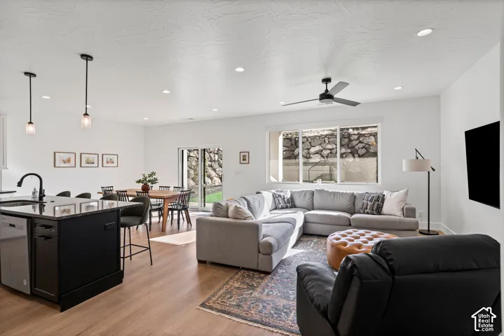 Open concept living area with wood-finish flooring, recessed lighting, and a ceiling fan