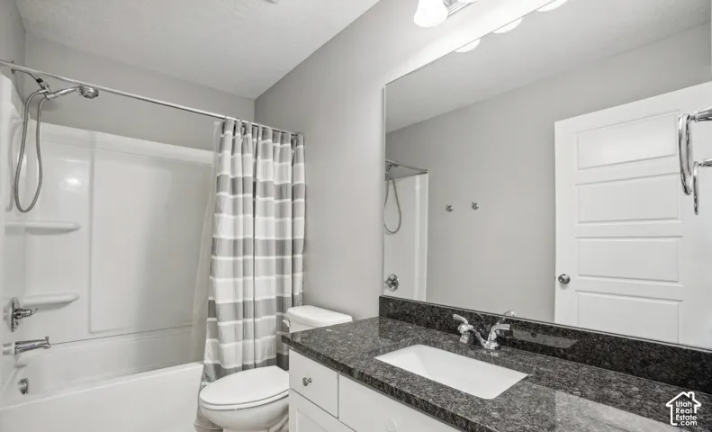 Contemporary bath with a shower/tub combination, granite-look countertop, white vanity cabinetry, and integrated mirror