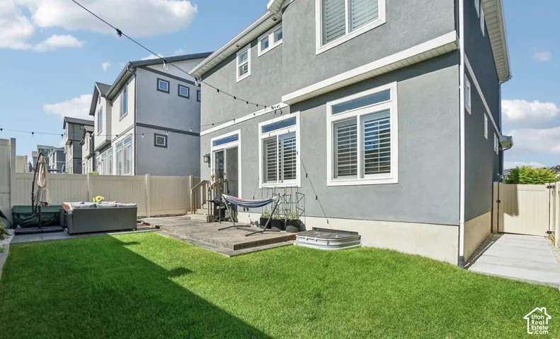 Manicured lawn with a concrete patio featuring steps and a sliding glass door