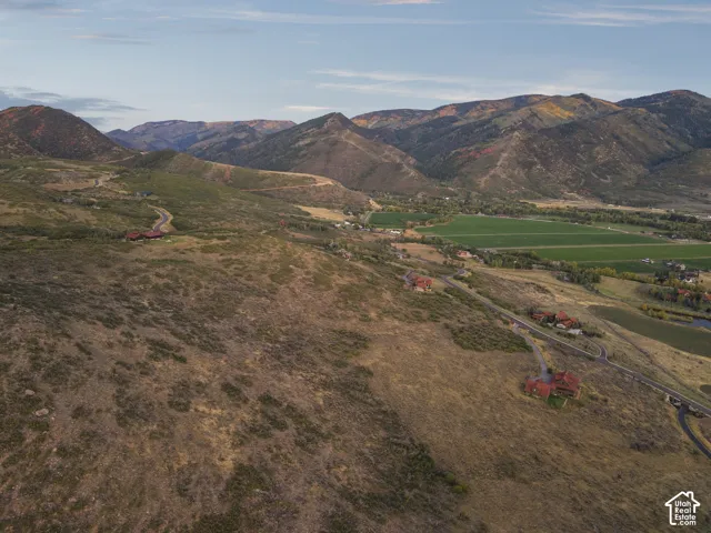 Expansive land featuring a paved road and mountainous backdrop