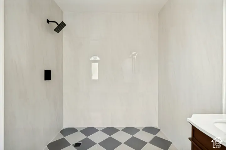 Walk-in shower with light-toned wall tiling and a matte black rain shower head