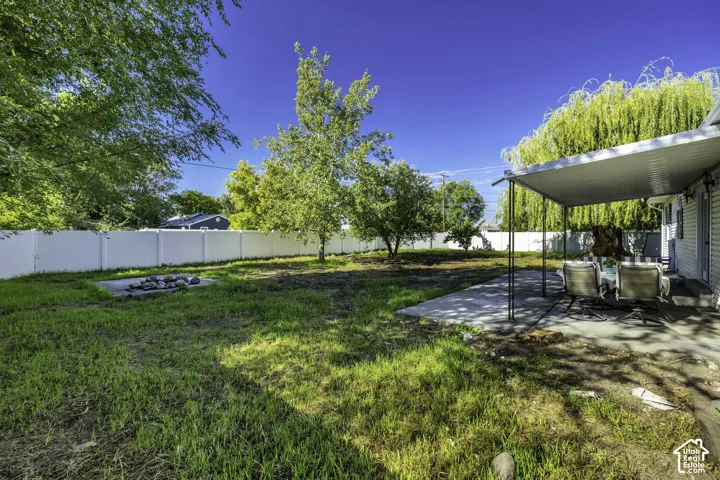 Spacious backyard with mature landscaping, manicured lawn, and established trees providing natural shade