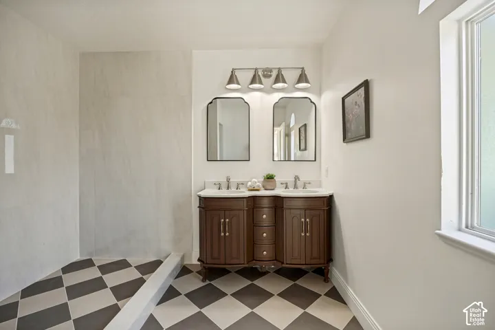 Dual vanity with white countertop, dark wood-finish cabinetry, and brushed nickel fixtures