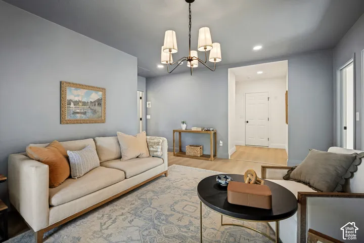 Recessed lighting and a decorative chandelier illuminate the space