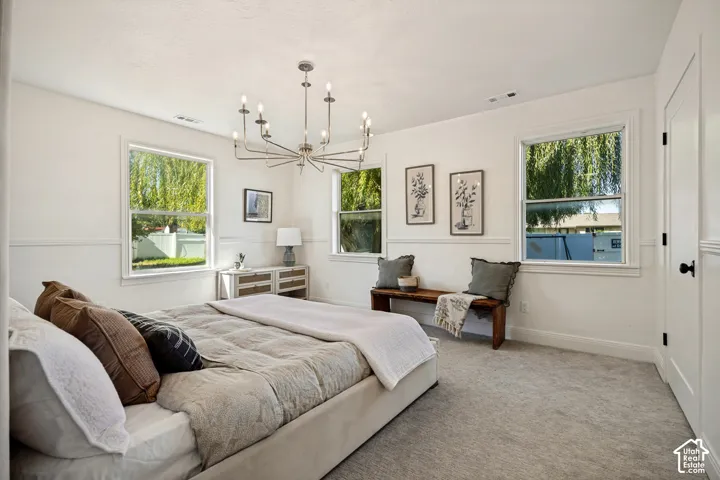 Recessed panel wainscoting, light-toned carpeting, and a multi-arm chandelier create a refined atmosphere
