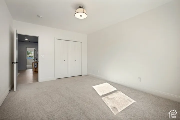 Neutral-toned walls, recessed lighting, and light-colored carpeting