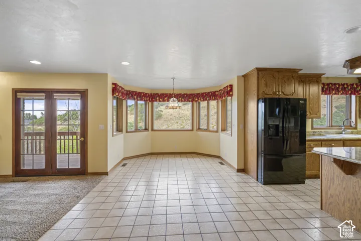 Tiled flooring with bay windows, wood cabinetry, and a built-in refrigerator