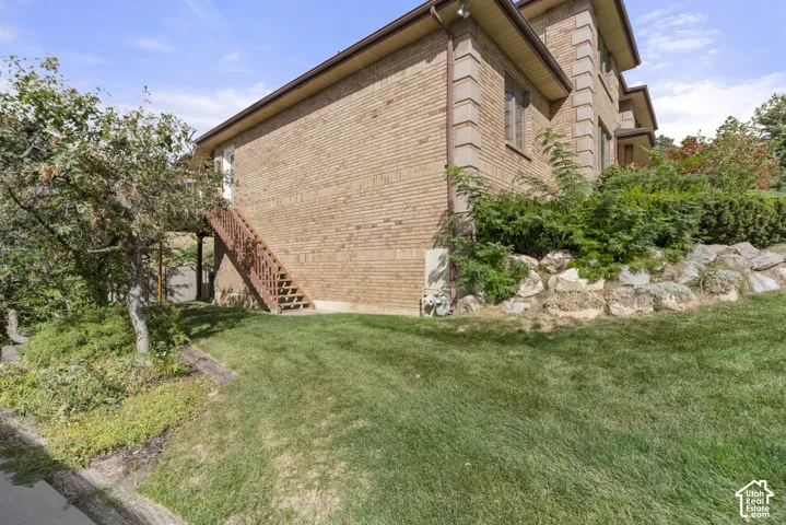 Brick exterior with stone accents and a sloped lawn
