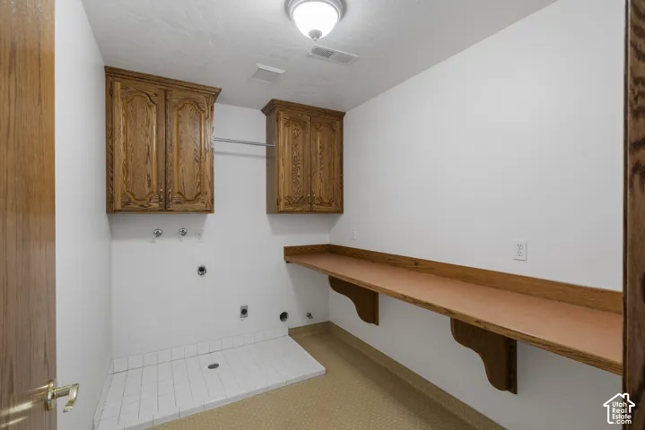 Built-in wood-finish cabinetry, integrated hanging rod, and a spacious wood-finish countertop