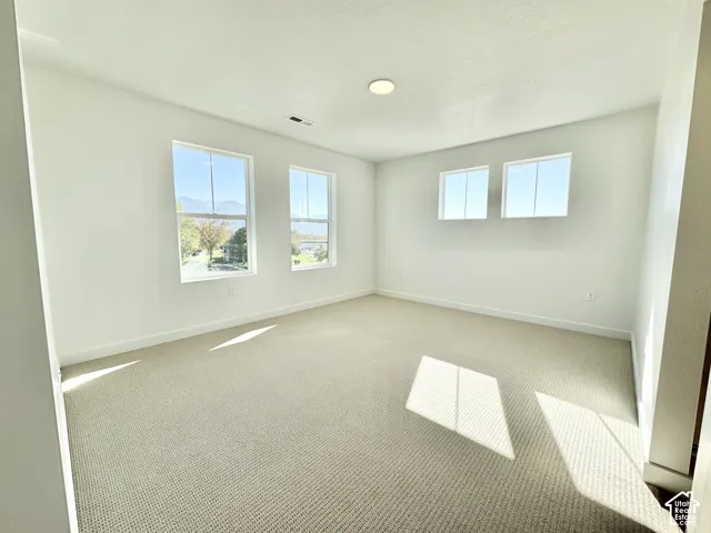 Neutral tone walls, recessed lighting, and light-colored carpeting