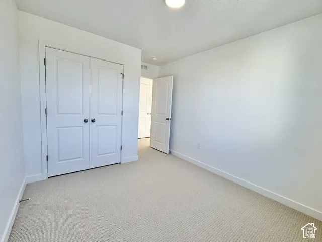 Neutral carpeting, white walls, and a recessed ceiling light