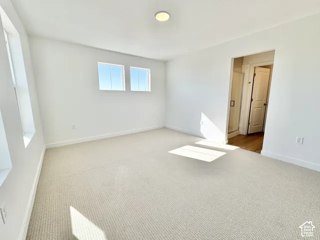 Room featuring light-colored carpeting and white walls
