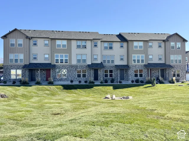 Multi-story exterior with varied siding materials, stone facade detailing, and individual covered entryways