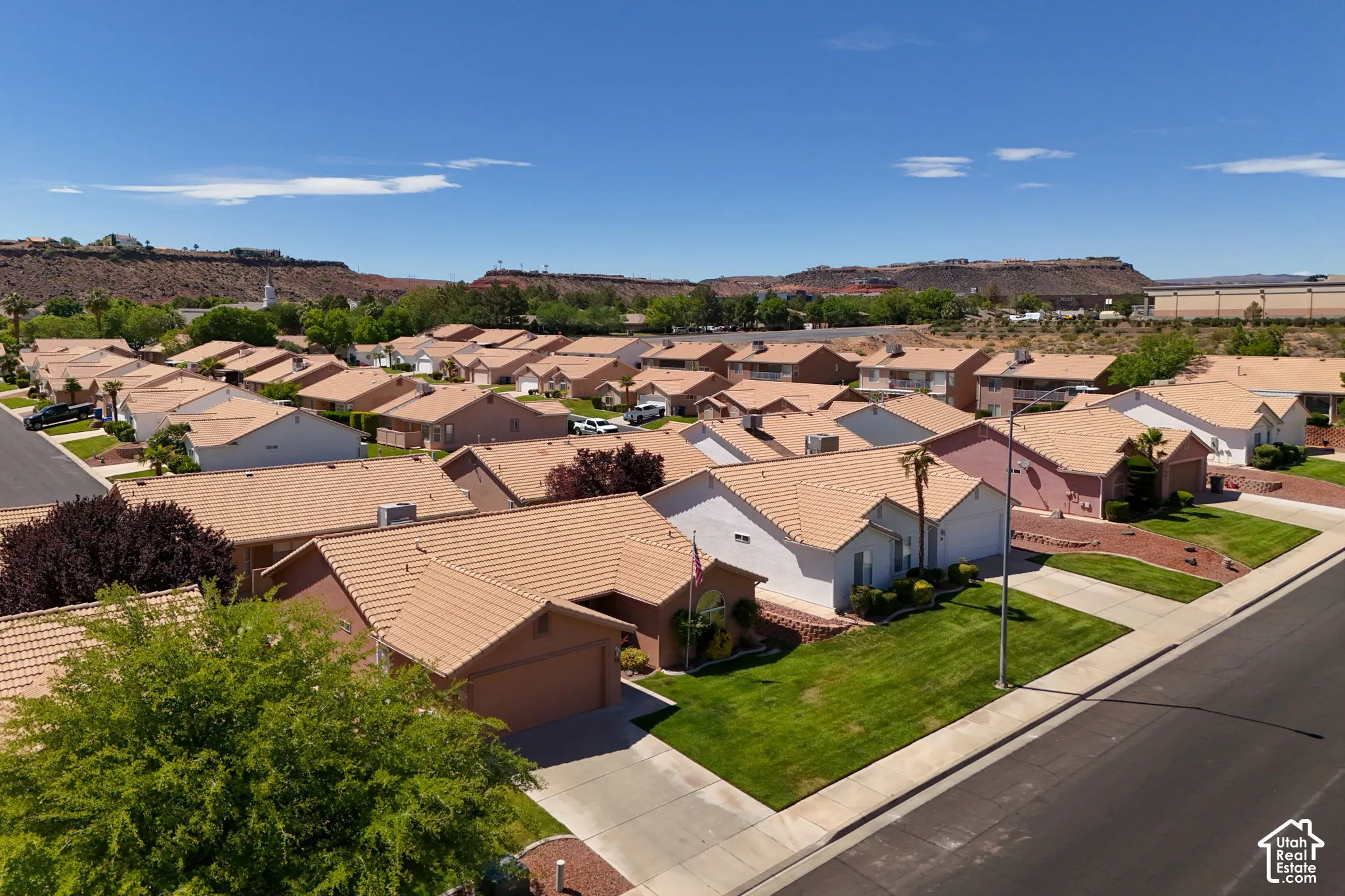 Residential neighborhood featuring single-story homes, concrete tile roofing, mature landscaping, and an asphalt street