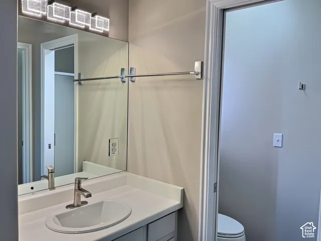 Vanity with a rectangular undermount sink, brushed nickel faucet, and a large mirror with integrated lighting