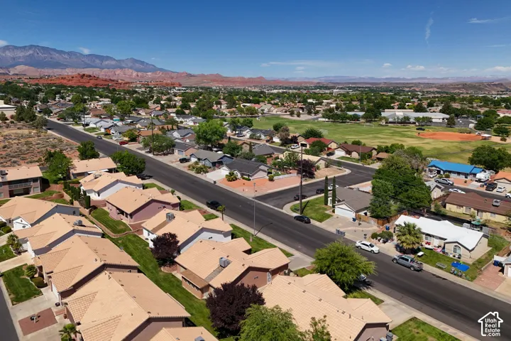 Residential neighborhood featuring single-story homes with pitched roofs, a paved street, and mature landscaping