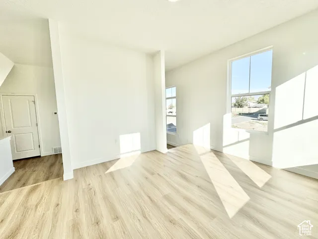 Wood-finish flooring throughout, white walls, and multiple windows