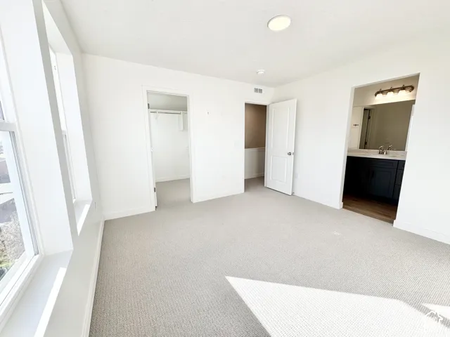 Carpeted room with multiple windows, recessed lighting, and a closet with shelving