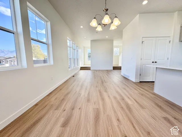 Spacious living area featuring wood-finish flooring, recessed lighting, and multiple large windows