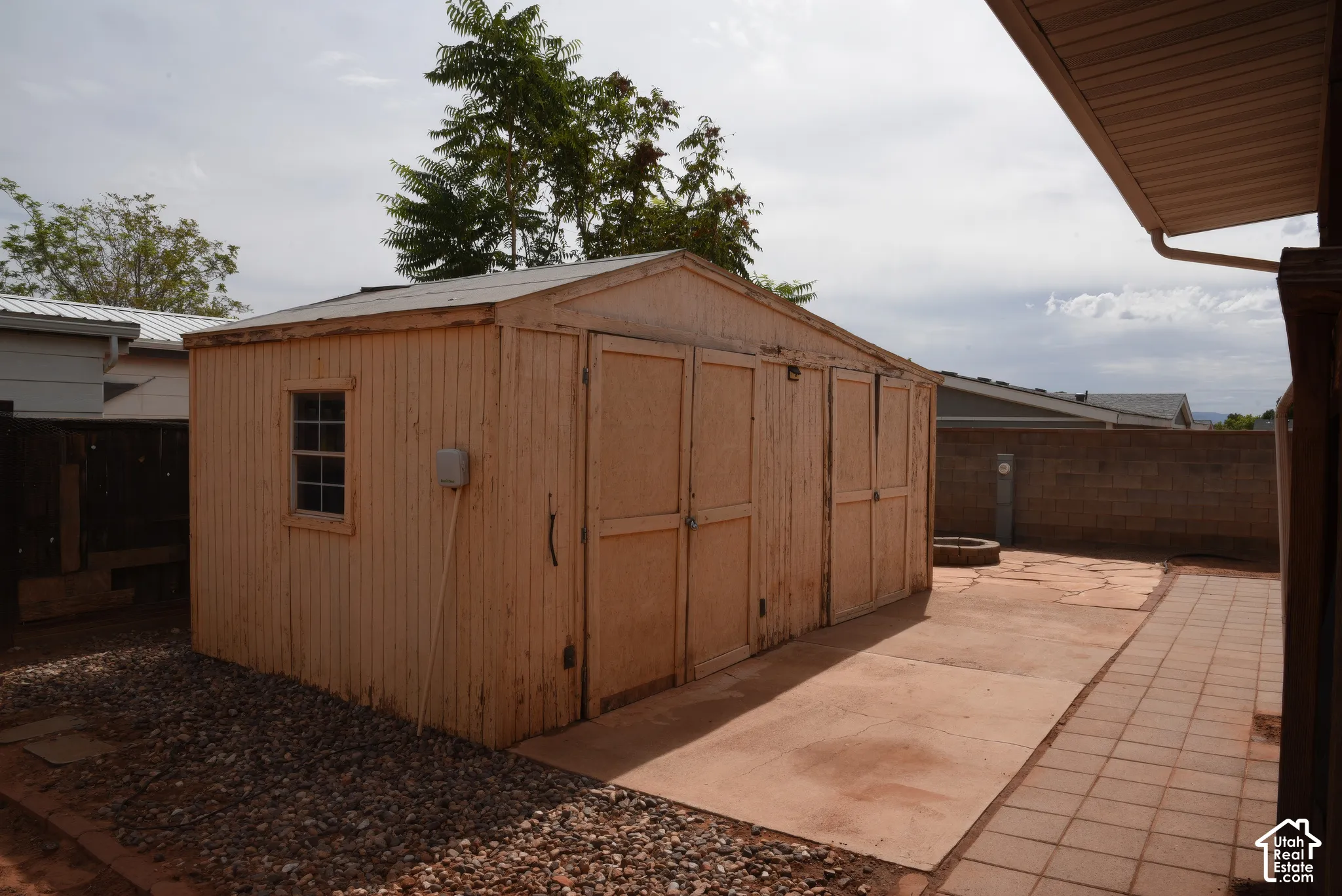 Work Shop with 220 outlet with multiple access doors and a single pane window, featuring a gravel perimeter and a concrete pad