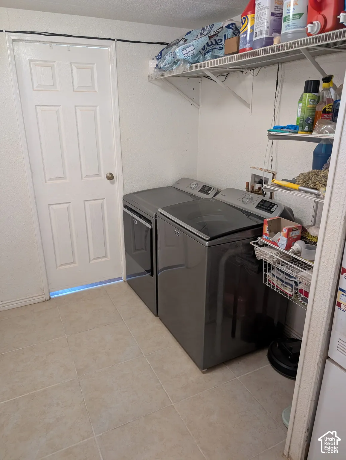 Dedicated utility area featuring tile flooring and built-in wire shelving