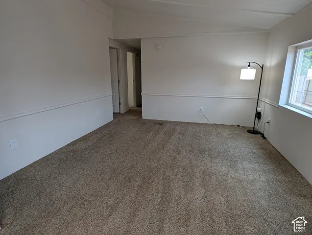 Neutral-toned carpeting throughout with white baseboards and chair rail molding
