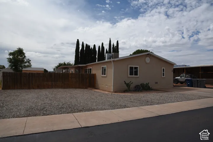 Tons of parking Pitched roof residence featuring a neutral exterior, a gravel front yard, and a wooden privacy fence