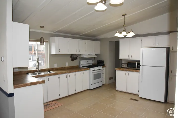 White cabinetry with brushed nickel hardware, laminate countertops, tile flooring, and a stainless steel double basin sink