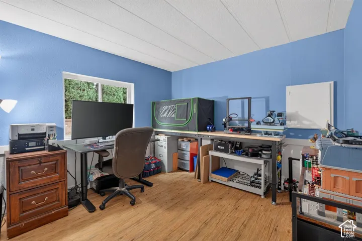 Room featuring wood-finish flooring, a horizontal sliding window, and a white ceiling panel