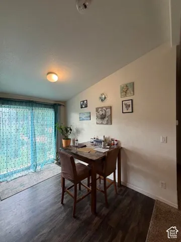 Wood-finish flooring throughout, complemented by a sliding glass door with sheer window treatments